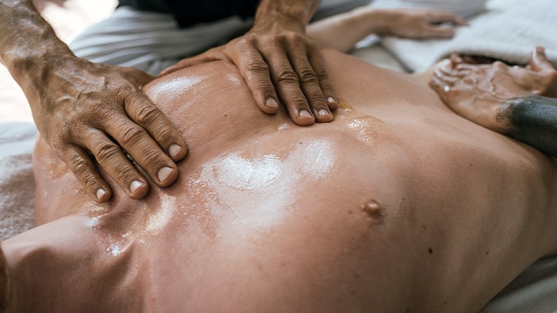 Terapeuta aplicando técnica da Massagem Lingam no Royal Therapy Spa com toque consciente e energia masculina.