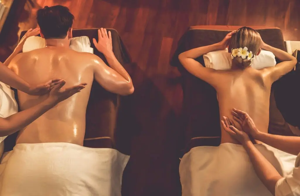 Massagens Fora do Royal – Bem-Estar Onde Estiveres 2 Casal a desfrutar de massagens fora do Royal Therapy Spa num quarto de hotel relaxante.